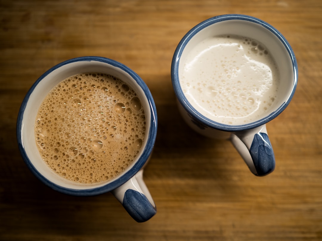 two-cups-of-coffee-sitting-on-top-of-a-wooden-table-aotdgletl7g